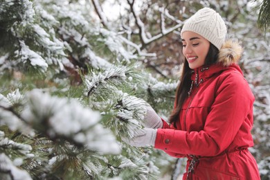 Photo of Happy young woman near tree in forest on winter day
