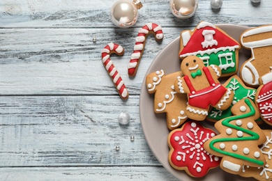 Flat lay composition with tasty homemade Christmas cookies on white wooden table, space for text