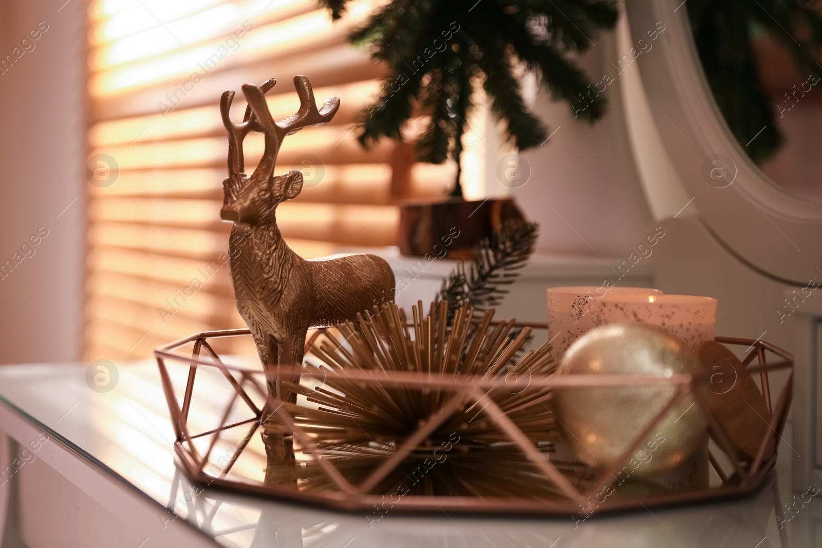Photo of Composition with decorative reindeer and Christmas tree near window on table, closeup