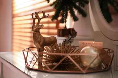 Photo of Composition with decorative reindeer and Christmas tree near window on table, closeup