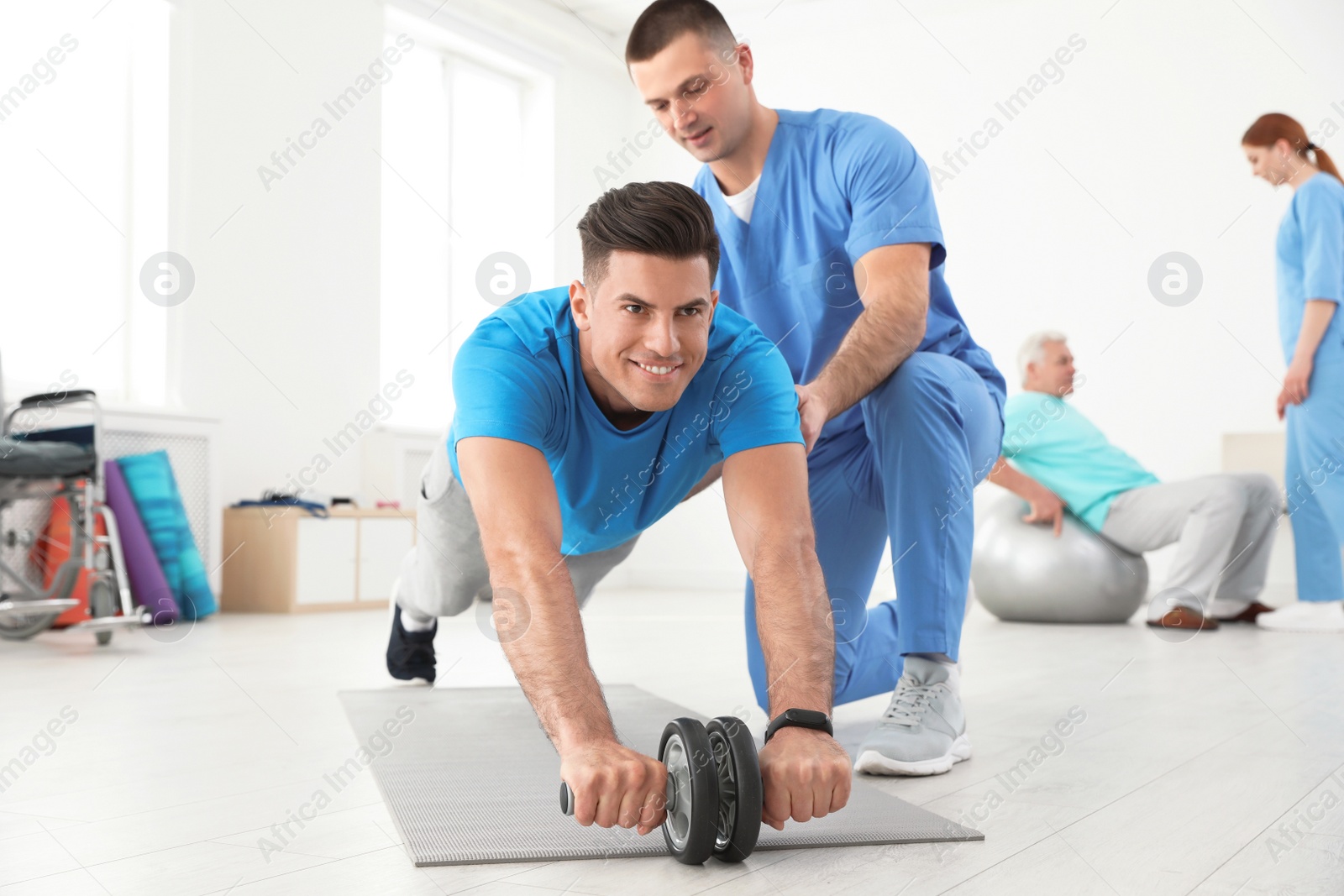 Photo of Professional physiotherapist working with male patient in rehabilitation center