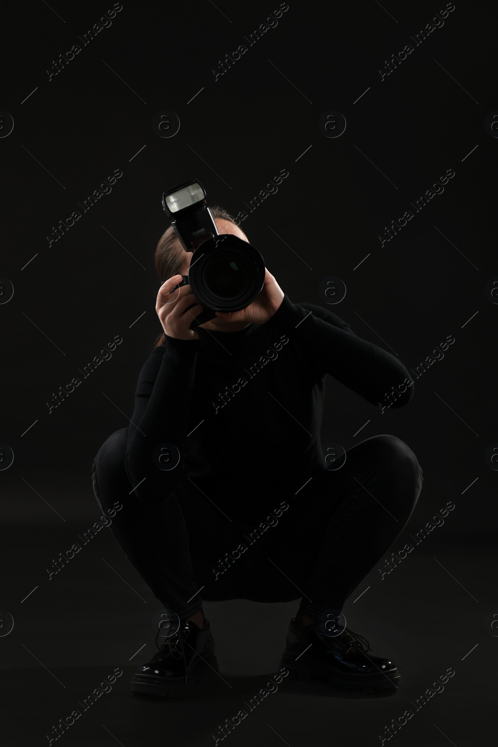 Photo of Professional photographer taking picture on black background