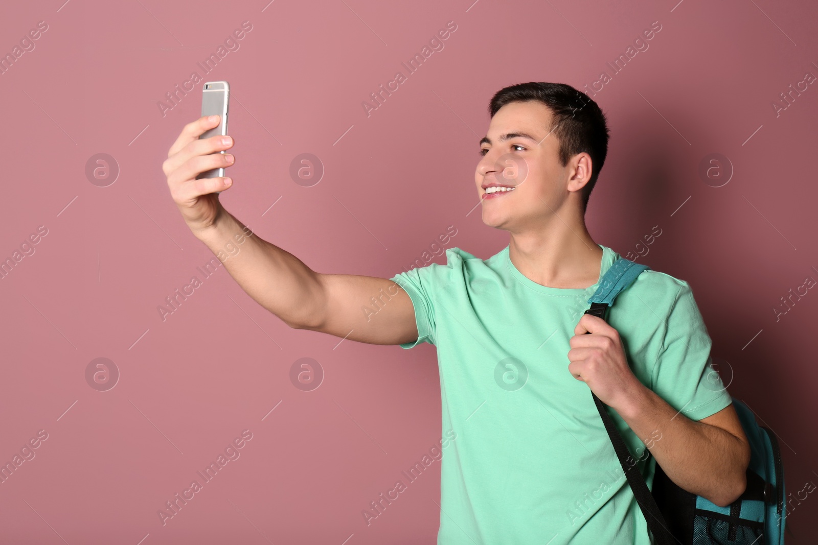 Photo of Young handsome man taking selfie against color background