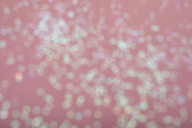 Photo of Blurred view of white glitter on pink background. Bokeh effect