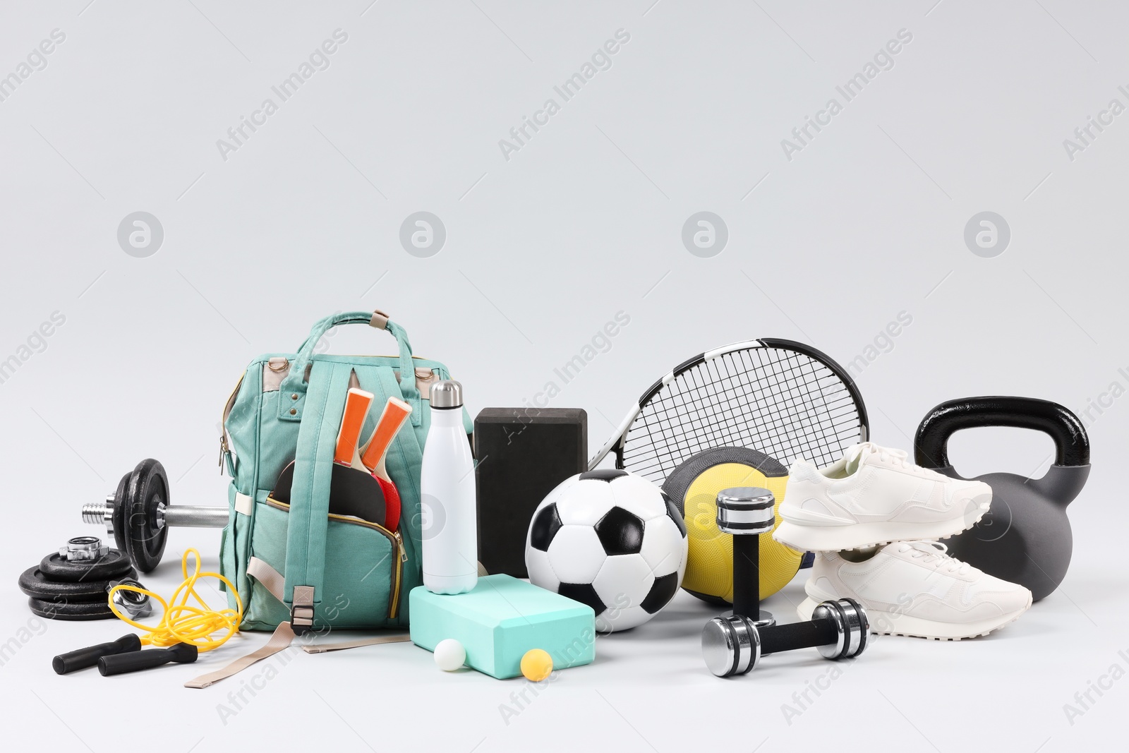 Photo of Many different sports equipment on light grey background