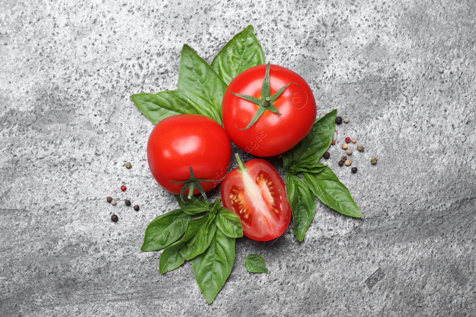 Photo of Flat lay composition with fresh basil leaves and tomatoes on grey table