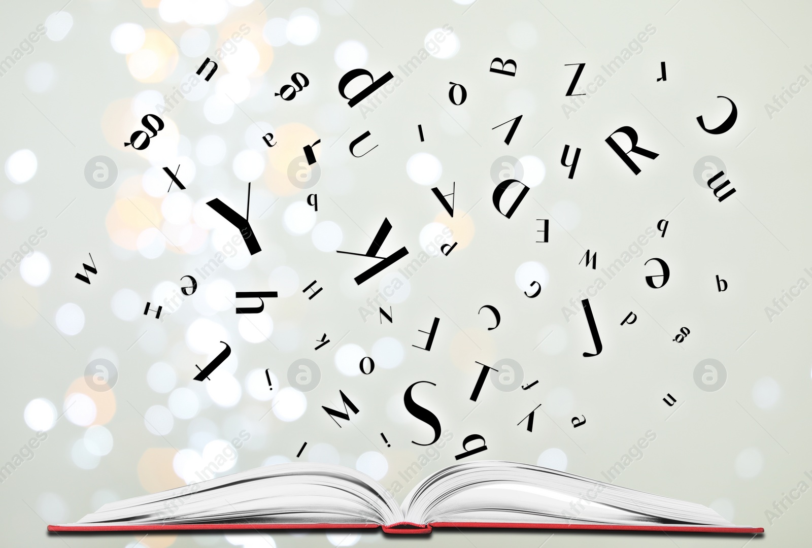 Image of Letters flying out from open book on light grey background, bokeh effect