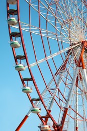 Beautiful large Ferris wheel against blue sky, low angle view