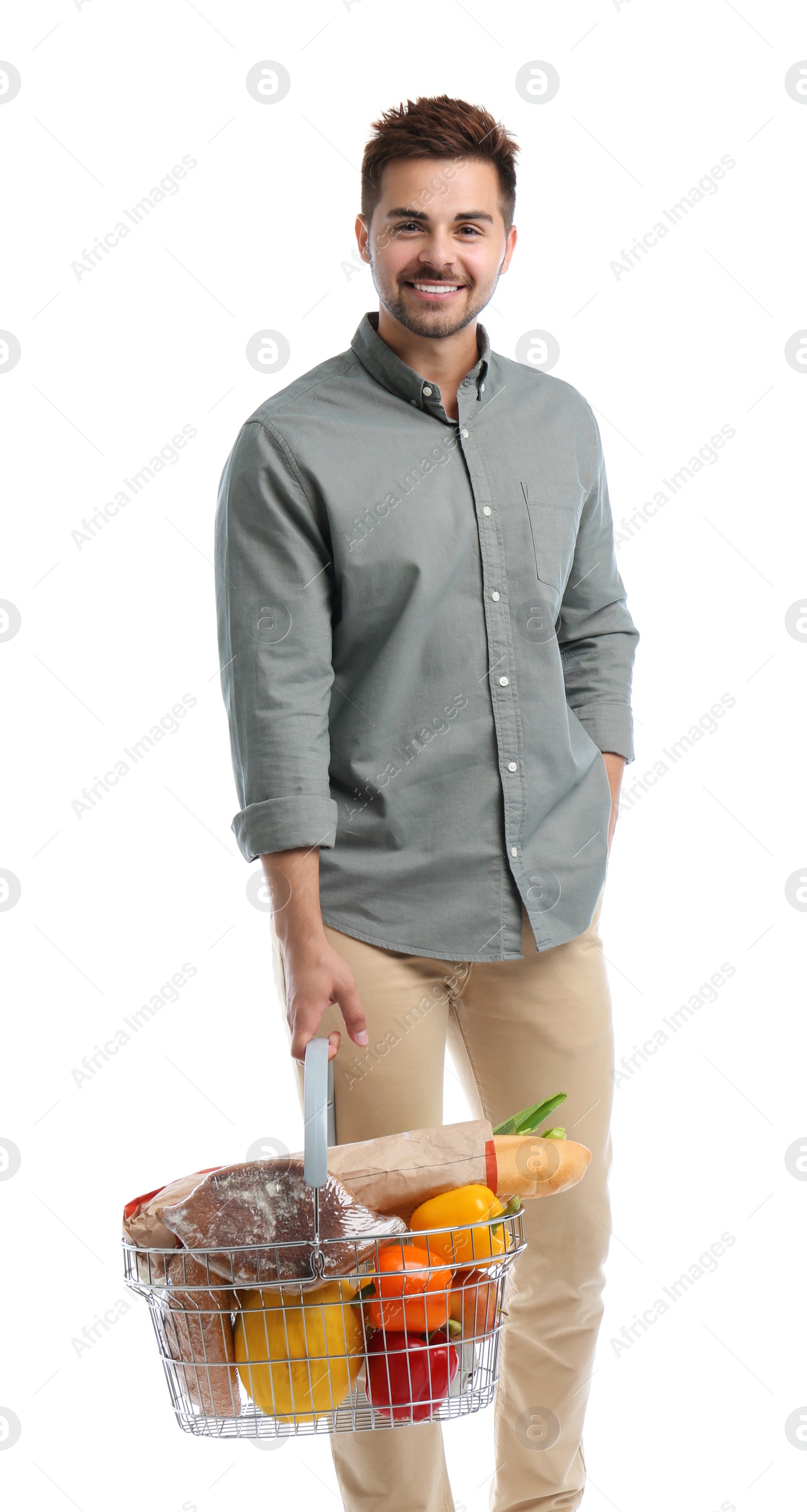 Photo of Young man with shopping basket full of products isolated on white