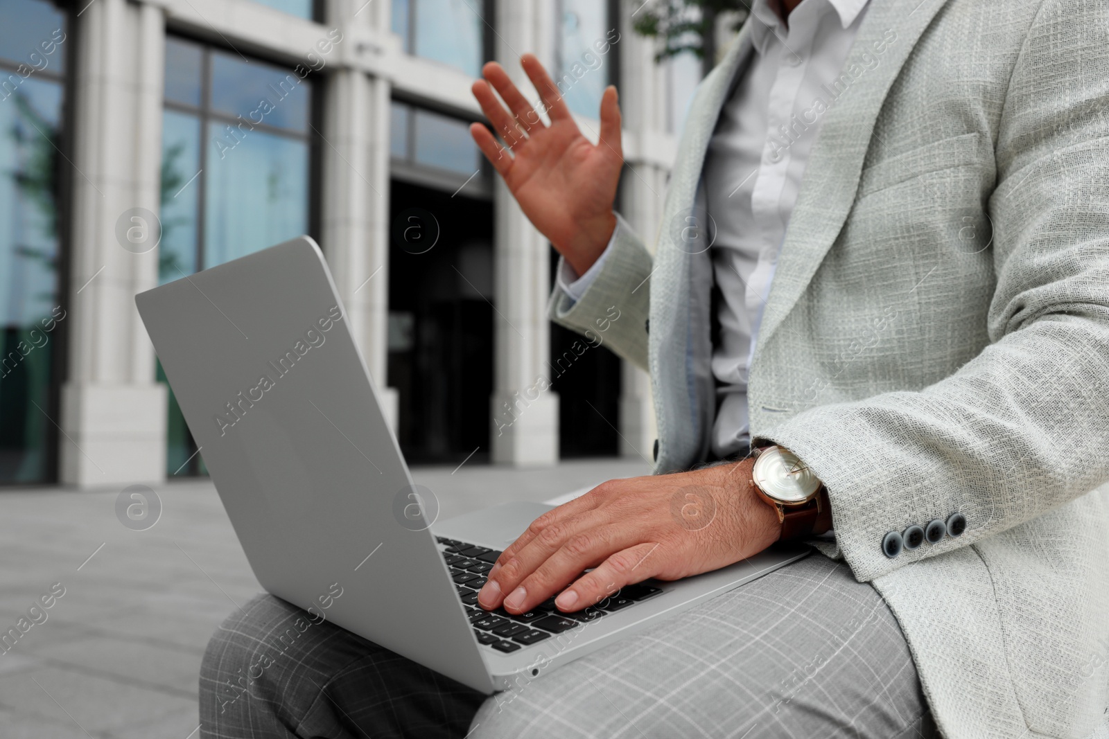 Photo of Businessman with laptop on city street, closeup