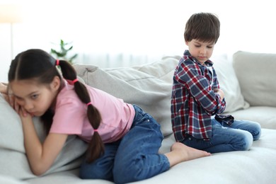 Photo of Upset brother and sister on sofa at home