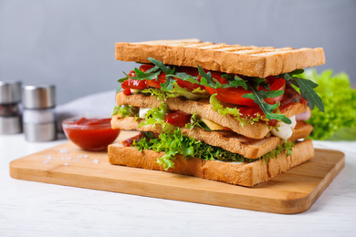 Yummy sandwich with tomato sauce on white wooden table