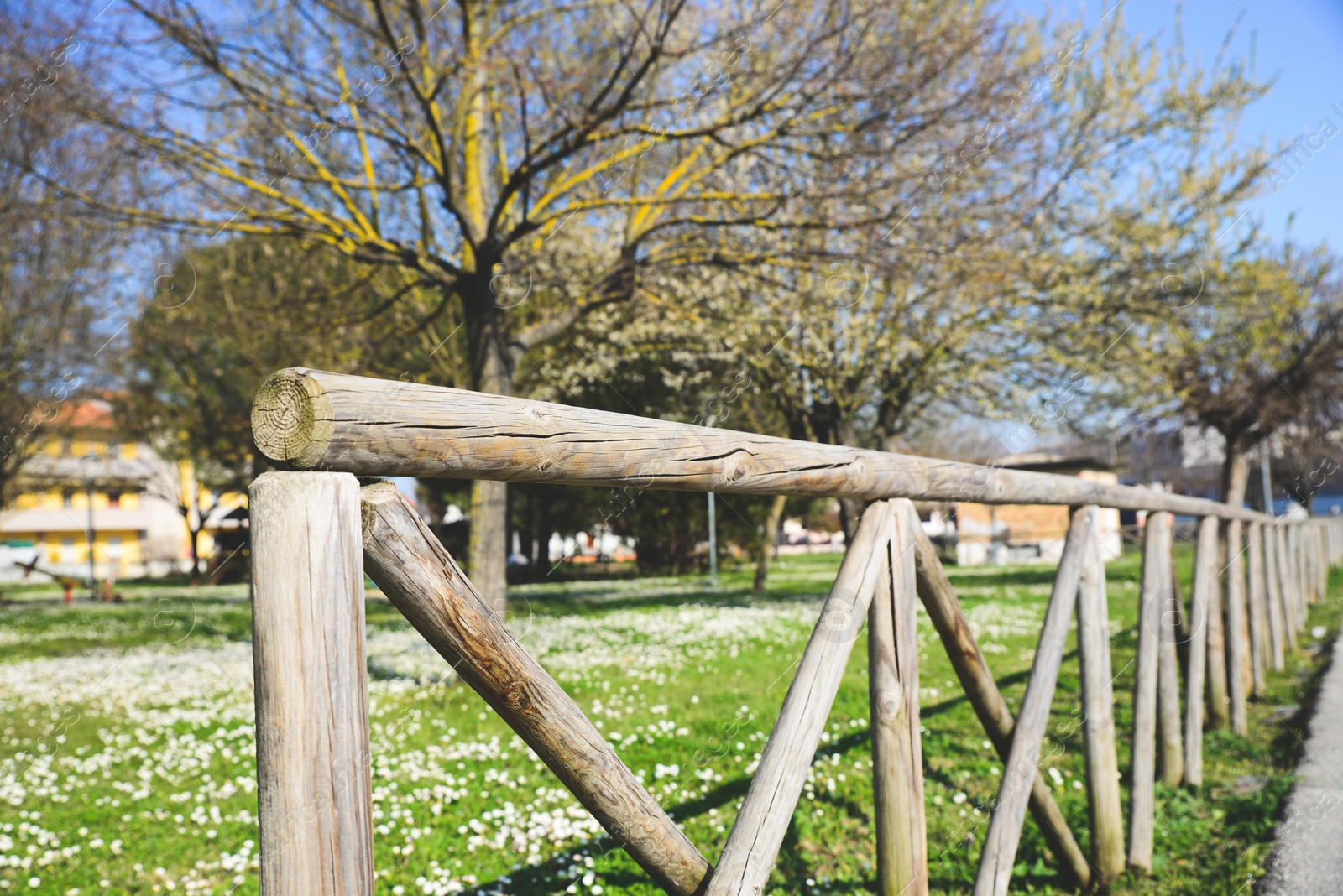 Photo of Rustic wooden fence in beautiful city park on sunny spring day