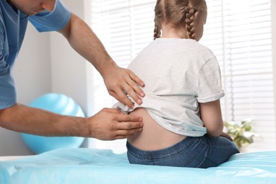 Orthopedist examining child's back in clinic, closeup. Scoliosis treatment