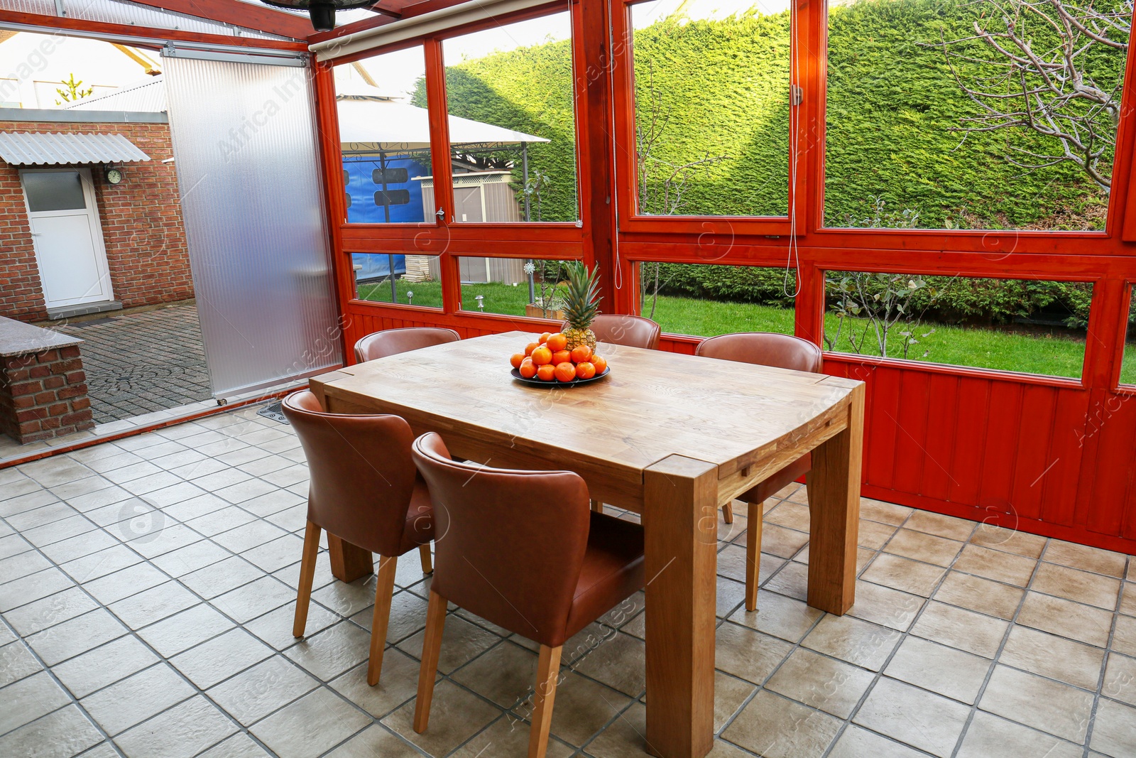 Photo of Wooden table with fruits and stylish chairs on terrace