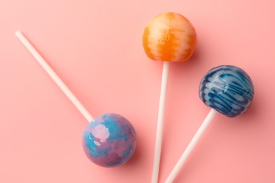 Photo of Tasty lollipops on pink background, flat lay