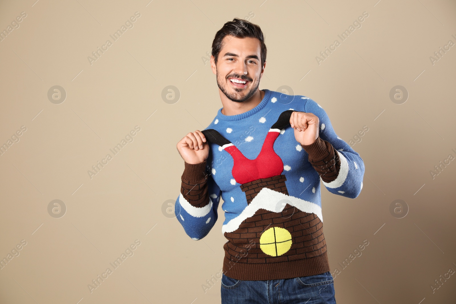 Photo of Portrait of happy man in Christmas sweater on beige background