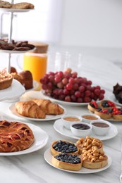 Variety of snacks on white marble table in buffet style indoors