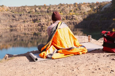 Photo of Male camper with sleeping bag in wilderness