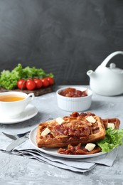 Photo of Delicious Belgium waffles served with fried bacon and butter on grey table, space for text