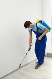 Photo of Pest control worker spraying pesticide in room
