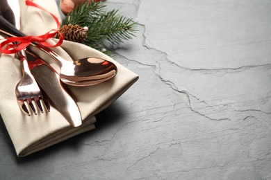 Photo of Cutlery set and festive decor on black slate table. Christmas celebration