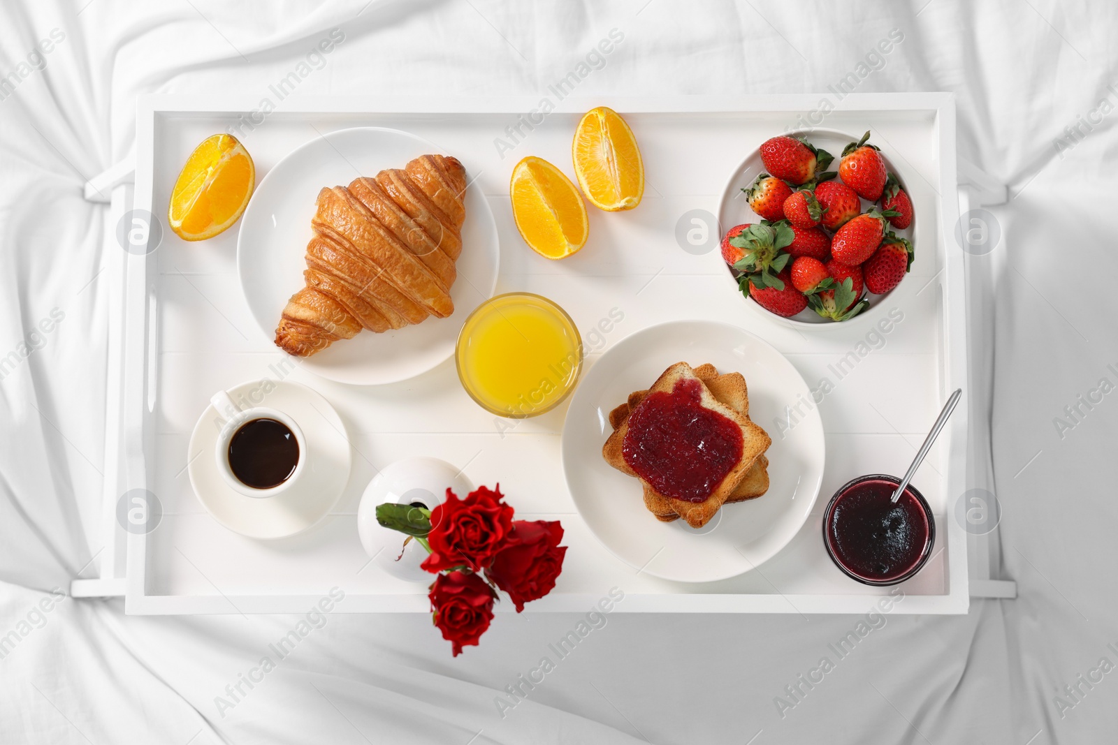 Tray with delicious breakfast on bed, top view Photo of Tray with delicious breakfast on bed, top view
