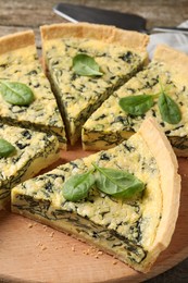 Cut delicious spinach pie on wooden board, closeup