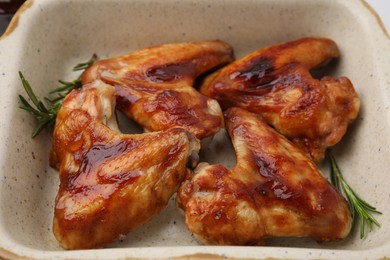 Photo of Fresh marinated chicken wings and rosemary in baking dish, closeup