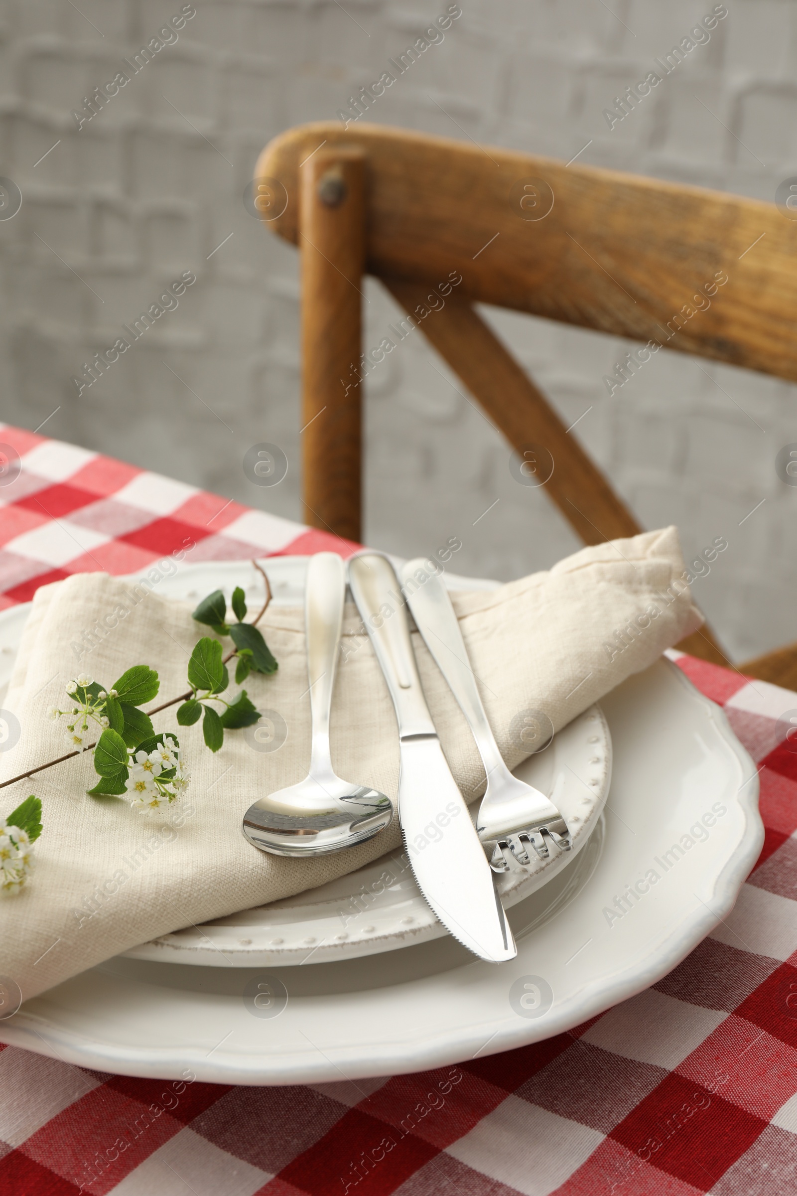 Photo of Stylish setting with cutlery, plates, napkin and floral decor on table