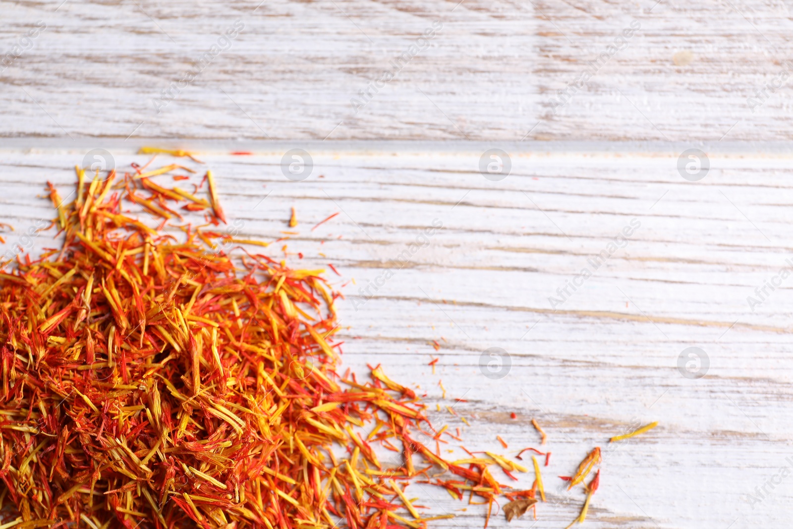 Photo of Aromatic saffron on wooden table, top view. Space for text