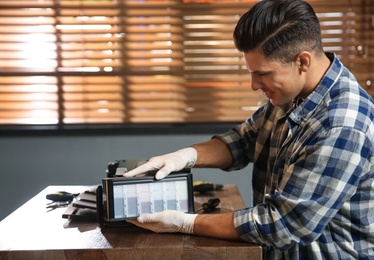 Professional repairman fixing modern printer in office