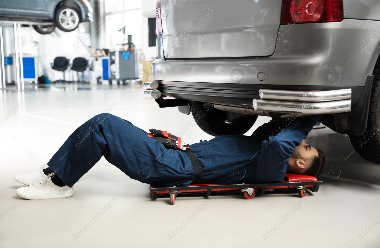 Photo of Technician checking modern car at automobile repair shop