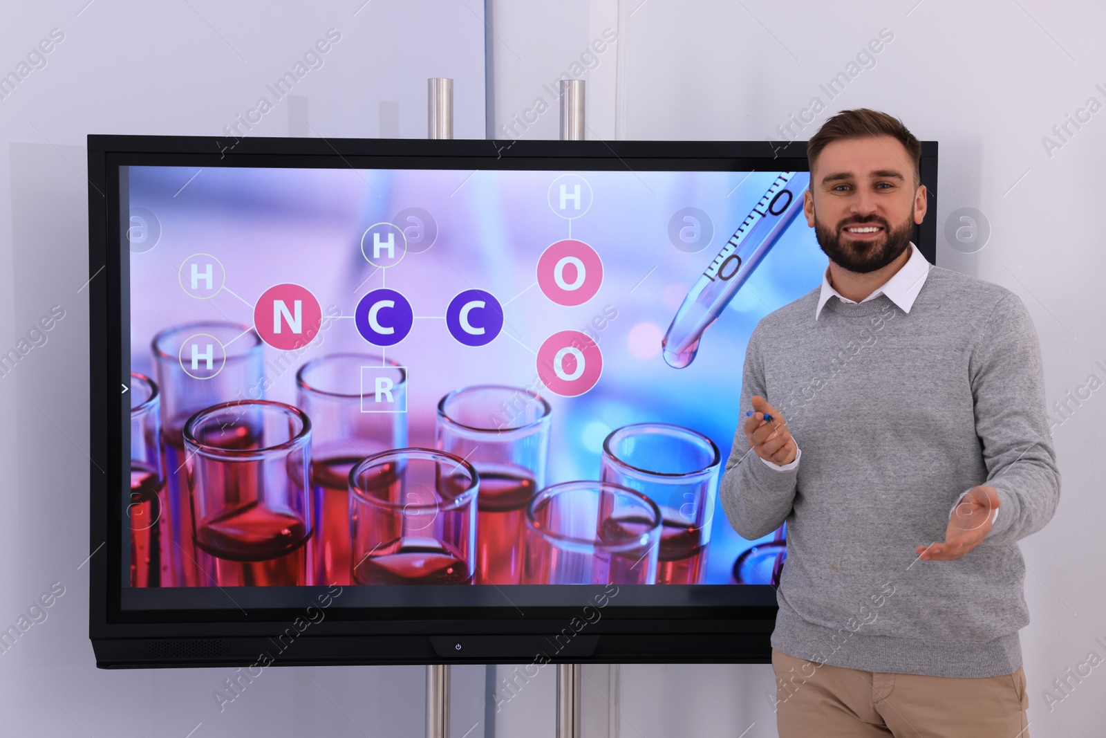 Photo of Teacher using interactive board in classroom during lesson