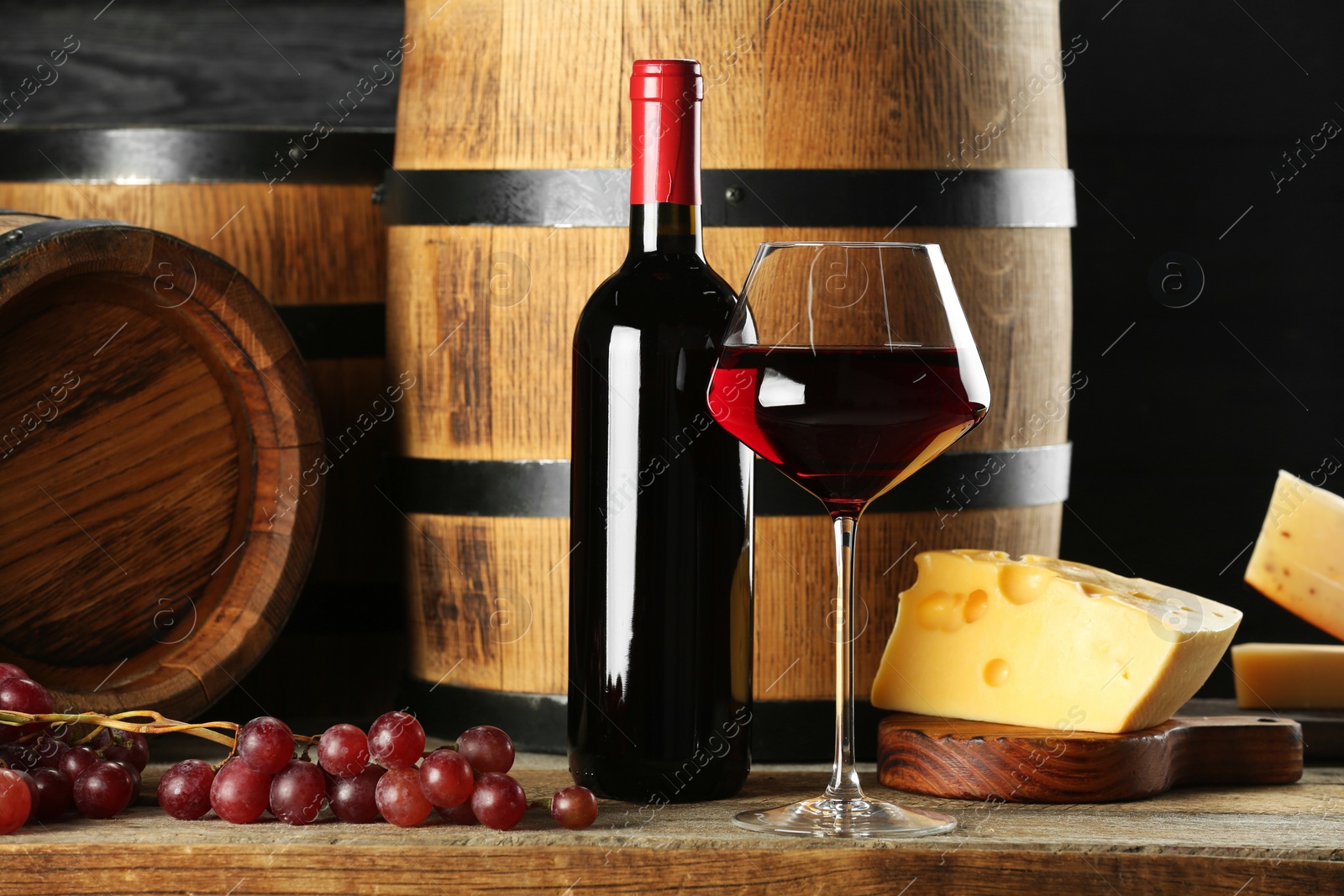 Photo of Winemaking. Composition with tasty wine and barrels on wooden table