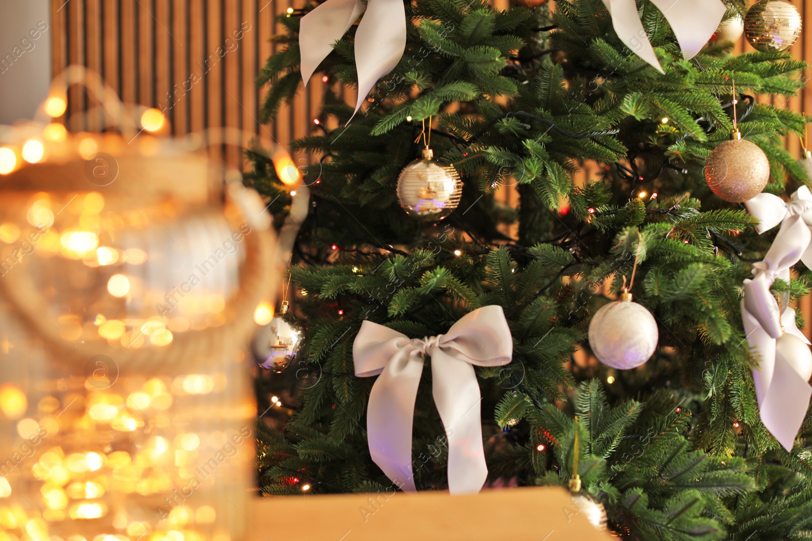 Photo of Christmas tree with stylish decor and fairy lights indoors