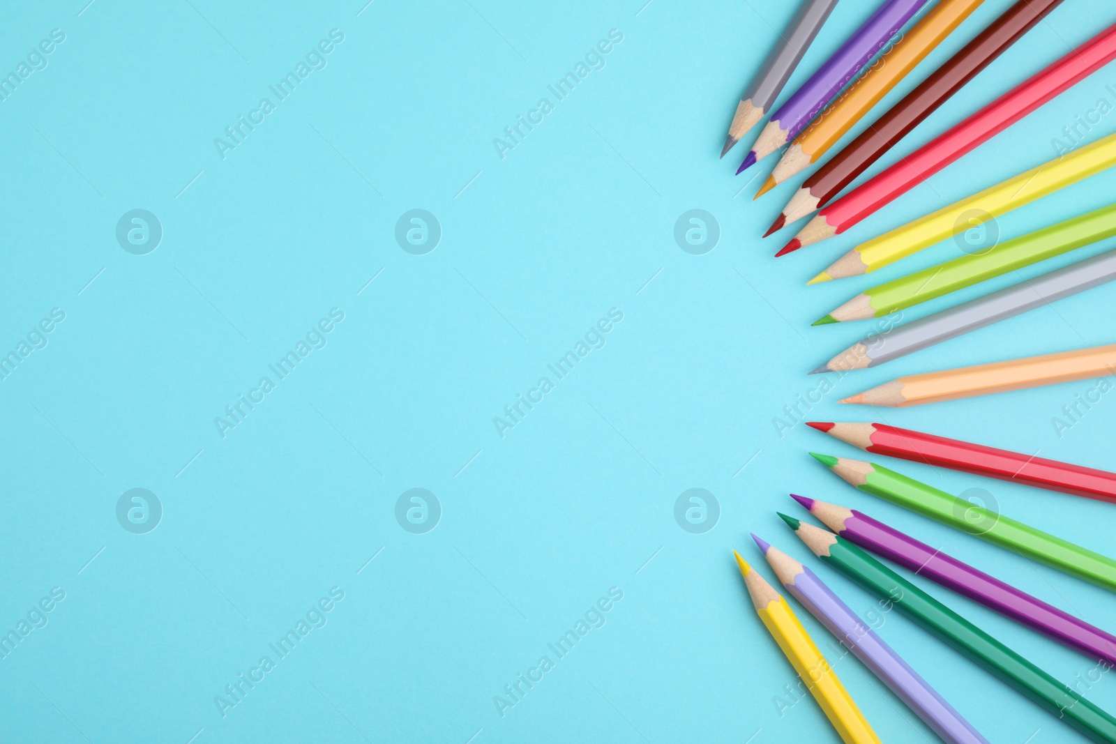 Photo of Colorful wooden pencils on light blue background, flat lay. Space for text