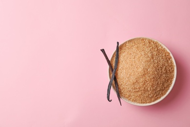 Photo of Bowl with brown vanilla sugar on color background, top view