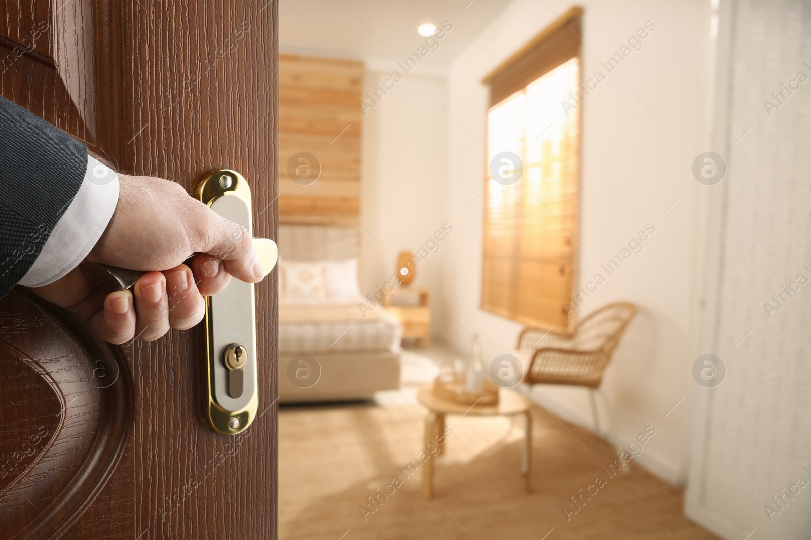 Image of Man opening wooden door to hotel room, closeup