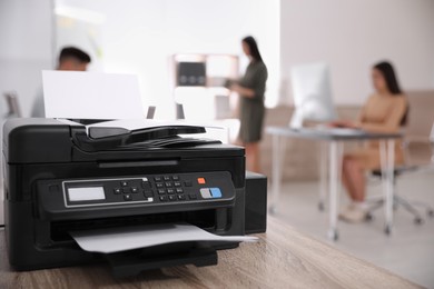 Photo of New modern printer on table in office. Space for text