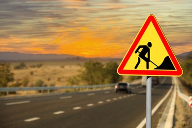 Image of Traffic sign Road Works near highway at sunset 