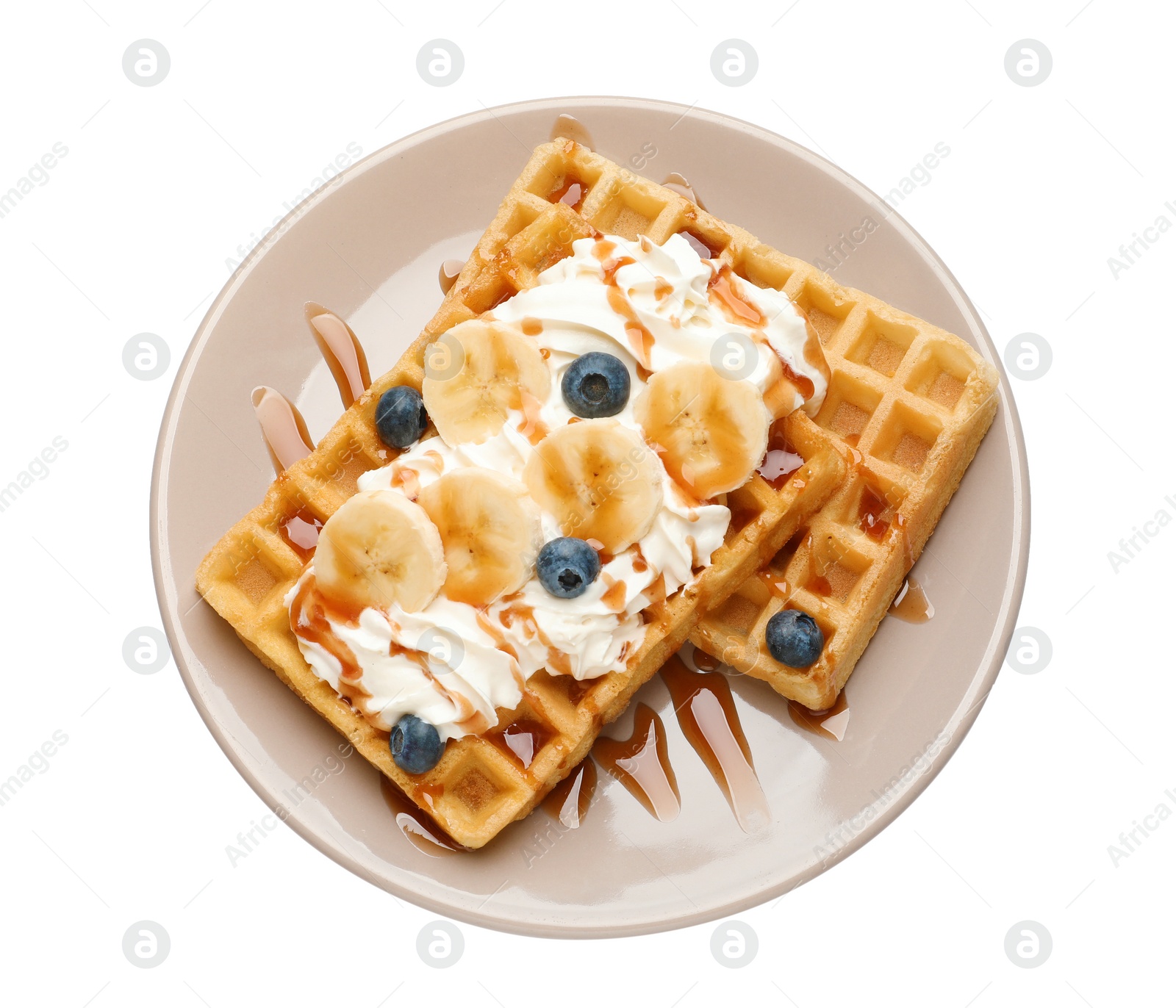 Photo of Plate with yummy waffles, whipped cream, blueberries and banana on white background, top view