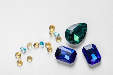 Photo of Different beautiful gemstones for jewelry on white background, flat lay. Space for text
