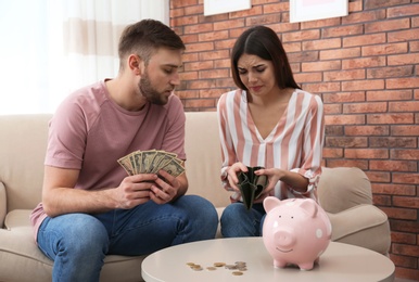 Unhappy young couple with money at home. Financial problems