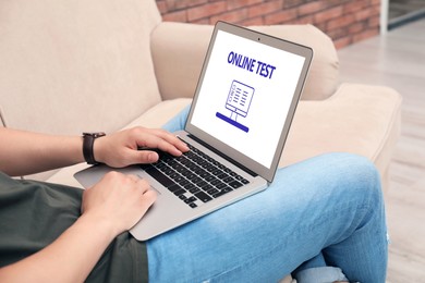 Man using laptop for online test indoors, closeup