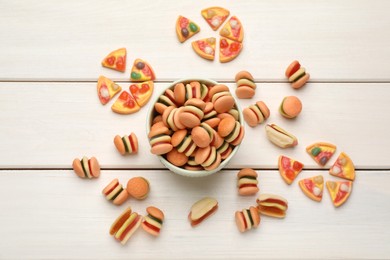 Many different delicious gummy candies on white wooden table, flat lay