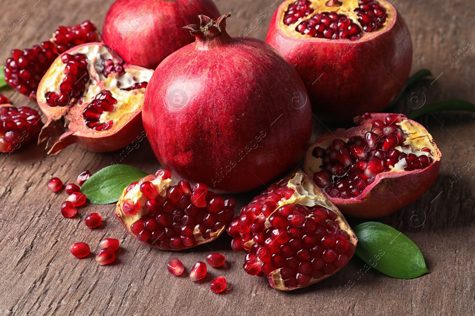 Photo of Composition with ripe pomegranates and leaves on color background