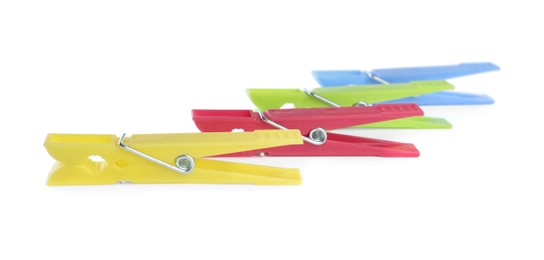 Many colorful plastic clothespins on white background