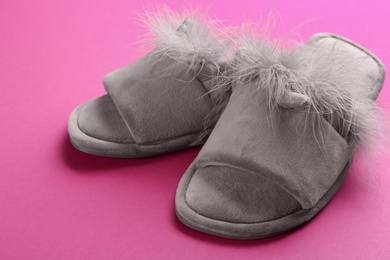 Pair of stylish soft slippers on pink background