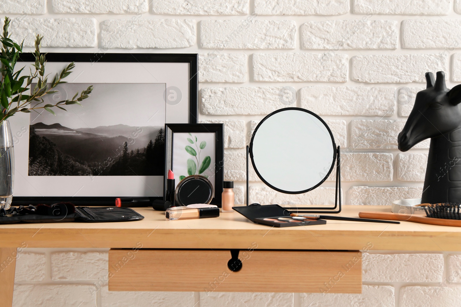 Photo of Dressing table with mirror, makeup products and accessories in room